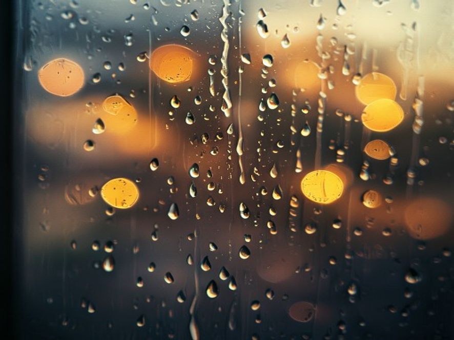 Rain on glass with warm bokeh — ambient, looping, no face needed.